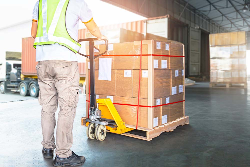 man pushing a pallet of boxes