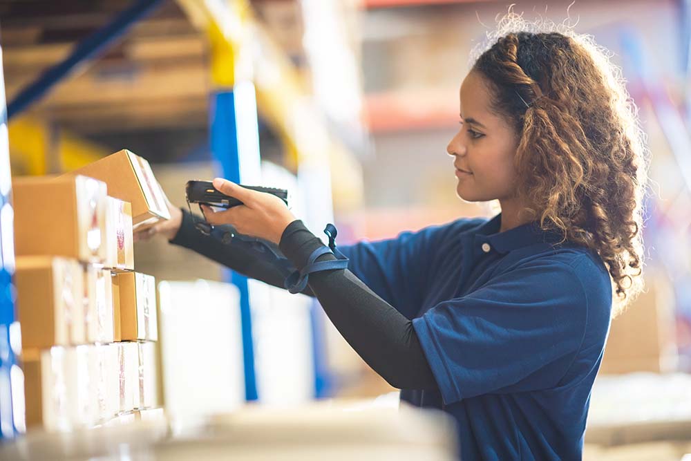 African American woman are work with business distribution inventory in warehouse factory, female people working in safety occupation job for shipping industry manufacturing