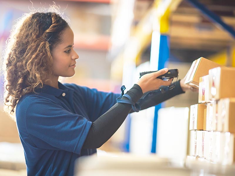 African American woman are work with business distribution inventory in warehouse factory, female people working in safety occupation job for shipping industry manufacturing