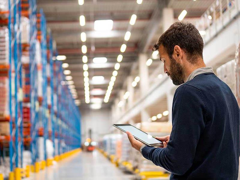 Manager in warehouse holding digital tablet