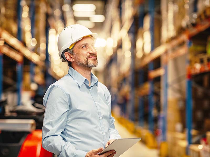 Man using a digital tablet and working in a distribution warehouse