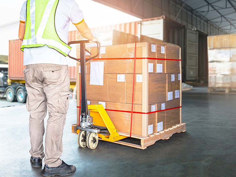 man moving packages into warehouse