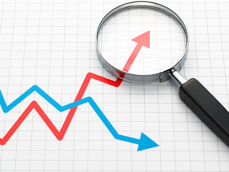 a magnifying glass and 2 trends lines